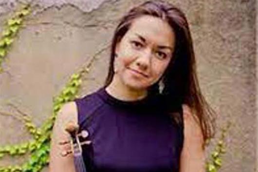 Headshot of violinist Ariana Kim standing in front of an ivy-covered wall